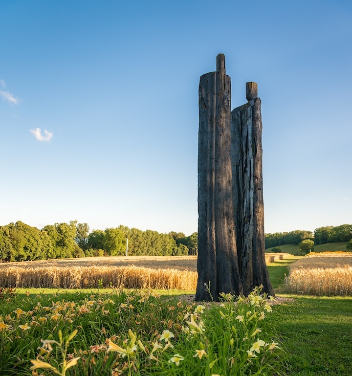 Sculpture de Christian Lapie représentant 2 hommes, géants. Ils sont en bois calcinés.