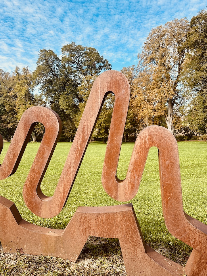 Sculpture "berg und tal" de l'artiste Gillian White en septembre avec les arbres orangées en arrière plan.