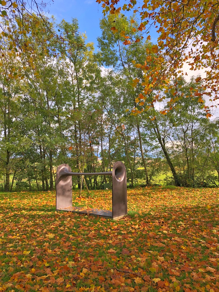 Oeuvre Dià de Michele Spanghero aux couleurs d'automne, avec des feuilles orangées au sol.
