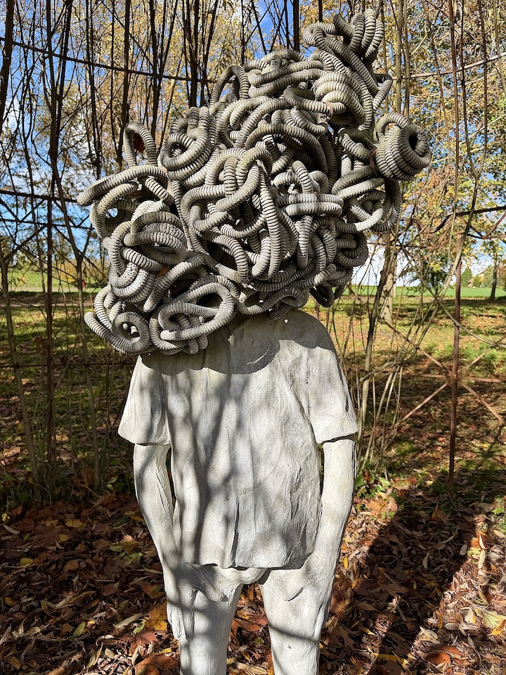 Vue rapprochée de l'oeuvre de Paolo Grassino représentant un homme avec le cerveau complètement emmêlés. Ce sont des tuyaux qui se mélangent.