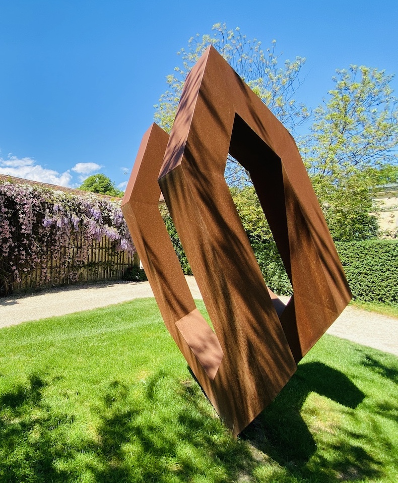 Sculpture de Werner Pokorny en acier corten (orange) en forme de maison, exposée au Château de Vullierens.