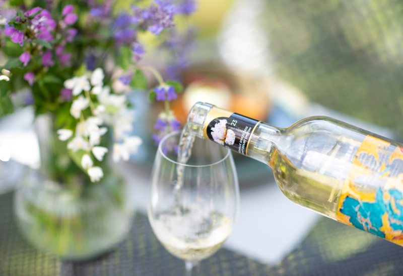 Du vin blanc est en train d'être servi dans un verre à pied.