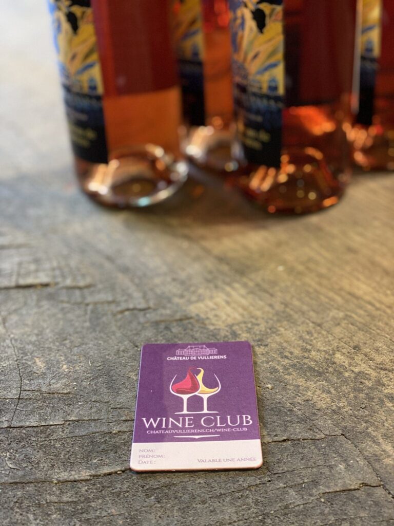 Carte Wine Club posée à côté de bouteille de rosé du Château de Vullierens.