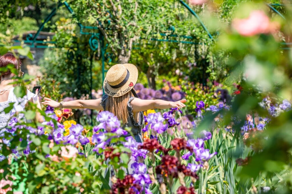 2 femmes en train de se prendre en photos au milieu des iris en fleurs du jardin de Doreen du Château de Vullierens.