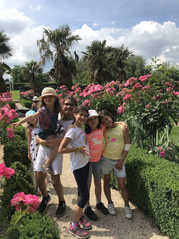 6 petites filles en train de s'amuser dans les allées de rosiers en fleurs dans le jardin de Doreen du Château de Vullierens.