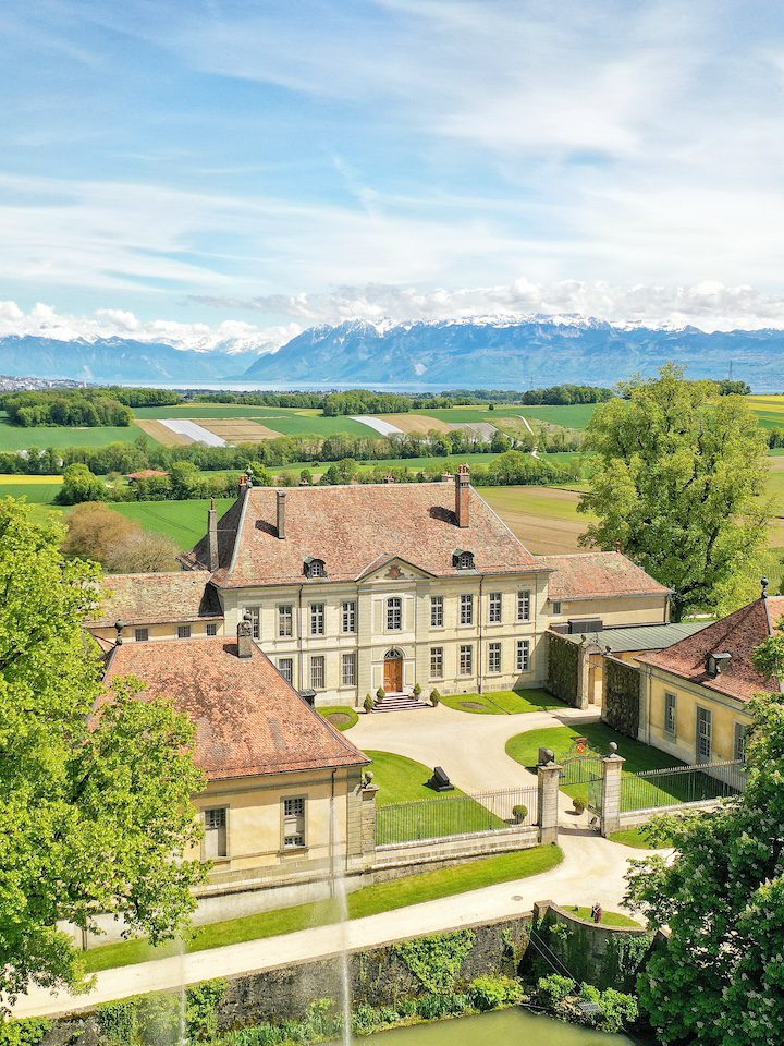 Vue aérienne du Château de Vullierens côté cour privé avec une vue sur le lac Léman, les alpes et la campagne autour.