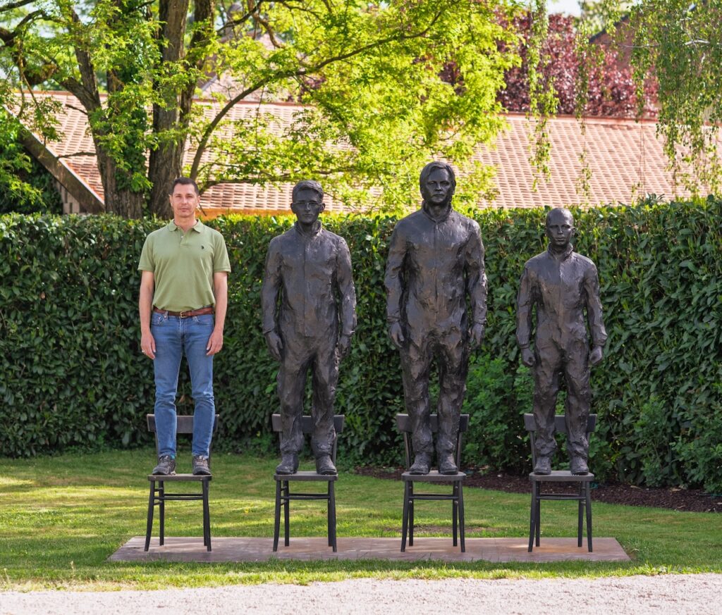 Un visiteur se tenant debout sur la sculpture "Anything to say ?" de Davide Dormino, exposée au Château de Vullierens, dans une démarche artistique de lutte.
