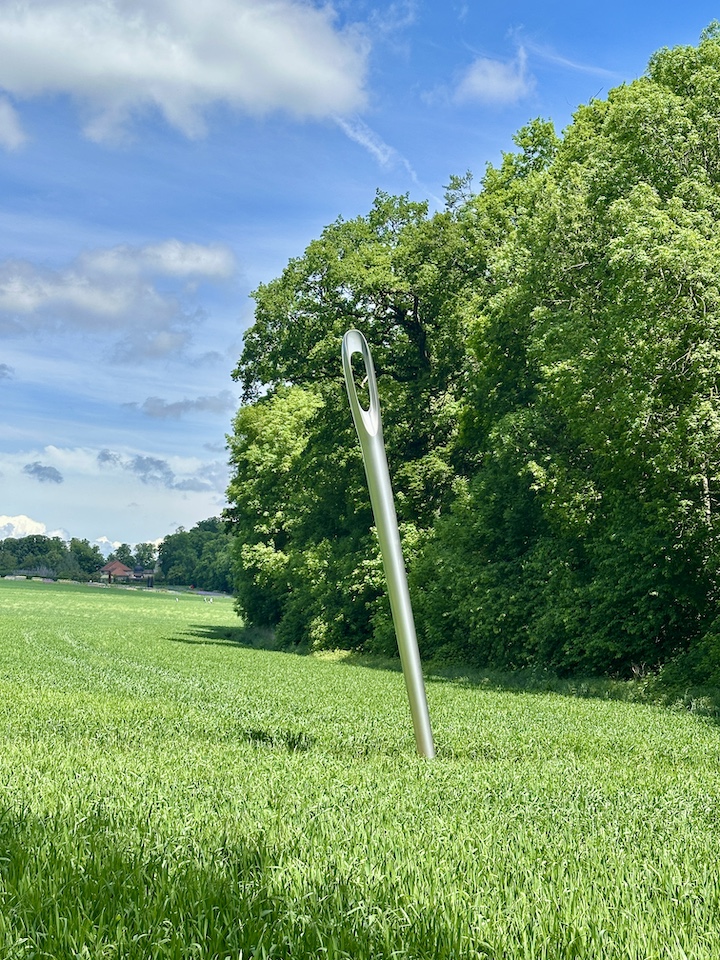 La sculpture "Dieu est une couturière" exposée dans un champ du domaine du Château de Vullierens. C'est une aiguille géante.